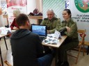 Zdjęcie przedstawia trzy osoby siedzące przy stoliku w tym dwie ze Straży Granicznej w Elblagu.