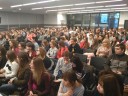 Zdjęcie przedstawia dużą grupę młodzieży oraz nauczycieli siedzącą w sali konferencyjnej.